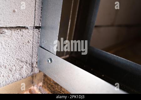 Zwei Metallprofile werden rechtwinklig mit einer selbstschneidenden Edelstahl-Schraube mit einer Bohrernaht verbunden. Montage des Rahmens für Trockenbauwände fr Stockfoto