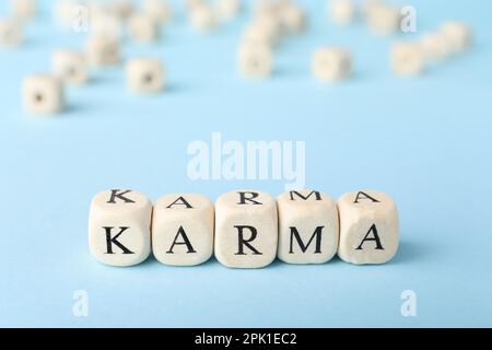 Wort Karma aus Würfeln mit Buchstaben auf hellblauem Hintergrund Stockfoto