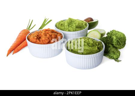 Verschiedene köstliche Püree in Schüsseln und frische Zutaten auf weißem Hintergrund. Gesundes Essen Stockfoto
