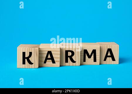 Wort Karma aus Würfeln mit Buchstaben auf hellblauem Hintergrund Stockfoto