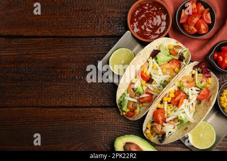 Köstliche Tacos mit Garnelen und Käse, serviert auf einem Holztisch, flach liegend. Platz für Text Stockfoto