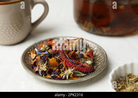 Aromatisch getrocknete Kräuter, Früchte und Beeren für Tee auf weißem Tisch Stockfoto