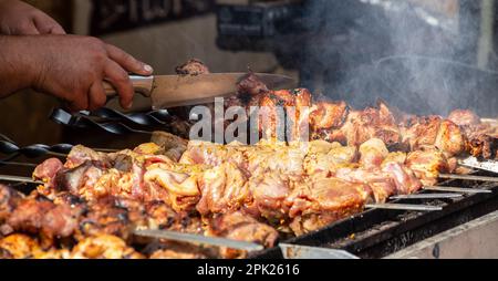 Marinierter Schaschlik, der auf einem Grillgrill über Holzkohle zubereitete. Shashlik oder Shish Kebab beliebt in Osteuropa. Schaschlyk, aufgespießtes Fleisch war Ursprung Stockfoto