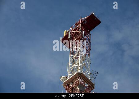 Telekommunikationsantenne für Radio, Fernsehen und Telefonie mit Wolke und blauem Himmel. Stockfoto