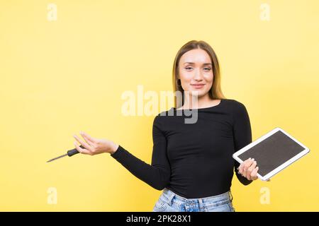 Service-Center. Laptop-Reparatur. Schraubendreher mit Innengewinde löst Laptopschrauben auf gelbem Hintergrund Stockfoto