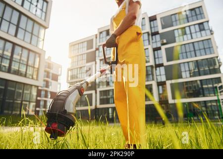 Ein Mann mäht das Gras mit einem Rasenmäher im Freien im Hof Stockfoto