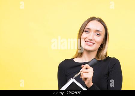 Service-Center. Laptop-Reparatur. Schraubendreher mit Innengewinde löst Laptopschrauben auf gelbem Hintergrund Stockfoto