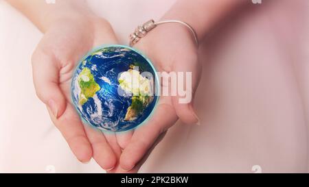 Schöner Planet Erde in weiblichen Händen. Elemente dieses von der NASA bereitgestellten Bildes. Stockfoto