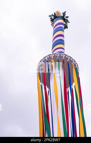 Farbenfrohe Bänder hängen an einer traditionellen englischen Maypole auf einer Dorffeier. Stockfoto
