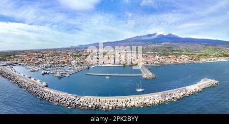 Riposto Sommerziel - Luftaufnahme vom Seehafen mit Booten an sonnigen Tagen mit Ätna-Vulkan im Hintergrund mit Meer Stockfoto