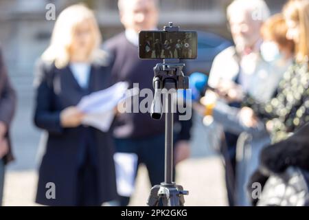 Filmen von Whistleblowern mit vertraulichen Dokumenten auf Medienveranstaltungen oder Pressekonferenzen mit einem Smartphone. Stockfoto