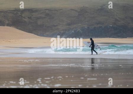 Isle of Lewis, Schottland. 5. April 2023 Wetter in Großbritannien: Ein nasser und windiger Start in die Osterferien auf der Isle of Lewis. Ein einsamer Surfer trotzt den Wellen am Eoropie Beach. Kredit: Bradley Taylor / Alamy Live News Stockfoto