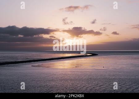 Sonnenuntergang am Wattenmeer, Niedersächsischer Waddenmeer-Nationalpark, UNESCO-Weltkulturerbe. Nordseeküste Ostfriesiens, Deutschland. Stockfoto