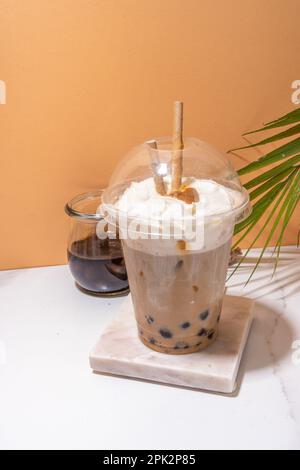 Tapioca boba Balls Coffee Frappe, asiatisch-trendiges kaltes Kaffeegetränk mit Tapiokasseln und Kokosnuss-Schlagsahne und Karamellsauce Stockfoto