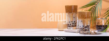 Boba dalgona Kaffee. Trendiges asiatisches Latte-Morgengetränk mit Instant-Kaffee und Tapioka-Perlkugeln, thailändisches Schaumcocktail-Glas im Sommer in der Sonne Stockfoto