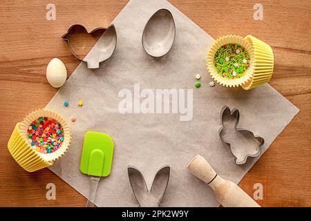 Osterbackidee: Schimmelpilze, Zuckerstreusel, Walznadel auf einem Holztisch. Festlicher Osterhintergrund zum Backen. Platz für Text. Kopierraum. Stockfoto