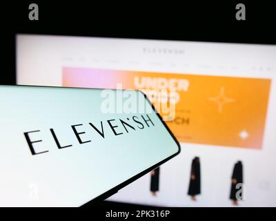 Mobiltelefon mit Logo des E-Commerce-Unternehmens ELEVENiSH auf dem Bildschirm vor der Business-Website. Fokus auf die Mitte rechts des Telefondisplays. Stockfoto