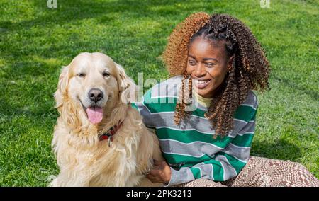 Golden Retriever und afrikanisches Mädchen Stockfoto