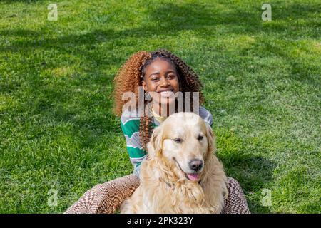 Golden Retriever und afrikanisches Mädchen Stockfoto