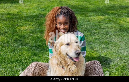 Golden Retriever und afrikanisches Mädchen Stockfoto