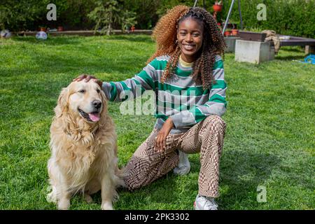 Golden Retriever und afrikanisches Mädchen Stockfoto