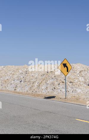 Kurve voraus, Warnschild auf einer einsamen, einsamen Straße in der Mojave-Wüste von Amboy, Kalifornien Stockfoto