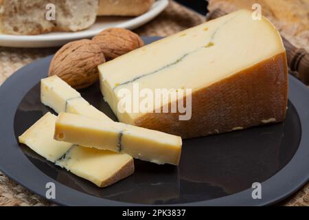 Käsesammlung, halbweicher Kuhmilchkäse von French Morbier mit schwarzer Schimmelschicht Stockfoto