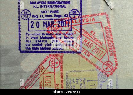 Innenseite eines gereisten ukrainischen Passes mit Stempeln vom Zoll Malaysias. Grenzstempel im Reisepass beim Überqueren der Staatsgrenze Malaysi Stockfoto