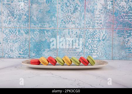 Bunte Makronen-Kuchen. Kleine französische Muffins. Süße und bunte französische Makronen. Bunte Makronen auf grauem Marmorhintergrund. Draufsicht. Pastellcolo Stockfoto