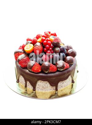 Kuchen mit Erdbeeren in geschmolzener Schokolade, Himbeere, Heidelbeere und roter Johannisbeere. Isoliert auf einfachem Hintergrund Stockfoto