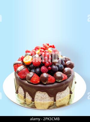 Kuchen mit Erdbeeren in geschmolzener Schokolade, Himbeere, Heidelbeere und roter Johannisbeere. Isoliert auf einfachem Hintergrund Stockfoto