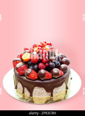 Kuchen mit Erdbeeren in geschmolzener Schokolade, Himbeere, Heidelbeere und roter Johannisbeere. Isoliert auf einfachem Hintergrund Stockfoto