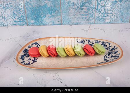 Bunte Makronen-Kuchen. Kleine französische Muffins. Süße und bunte französische Makronen. Bunte Makronen auf grauem Marmorhintergrund. Draufsicht. Pastellcolo Stockfoto