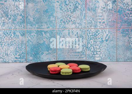 Bunte Makronen-Kuchen. Kleine französische Muffins. Süße und bunte französische Makronen. Bunte Makronen auf grauem Marmorhintergrund. Draufsicht. Pastellcolo Stockfoto