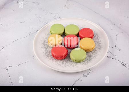 Bunte Makronen-Kuchen. Kleine französische Muffins. Süße und bunte französische Makronen. Bunte Makronen auf grauem Marmorhintergrund. Draufsicht. Pastellcolo Stockfoto