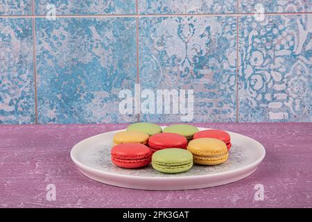 Bunte Makronen-Kuchen. Kleine französische Muffins. Süße und bunte französische Makronen. Bunte Makronen auf grauem Marmorhintergrund. Draufsicht. Pastellcolo Stockfoto