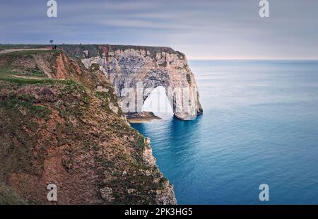 Besichtigungstour mit Blick auf die natürliche Bogenklippe Porte d'Aval, die von den Gewässern des Atlantischen Ozeans in Etretat, Normandie, Frankreich, gespült wird. Wunderschöne Küstenlandschaft mit Stockfoto