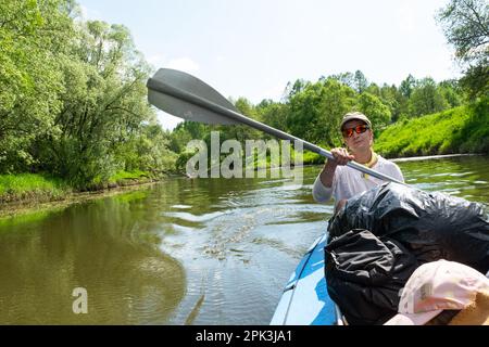 Familien-Kajakausflug. Vater und Tochter Ruderboot auf dem Fluss, eine Wasserwanderung, ein Sommerabenteuer. Umweltfreundlicher und extremer Tourismus, aktiv und gesund Stockfoto