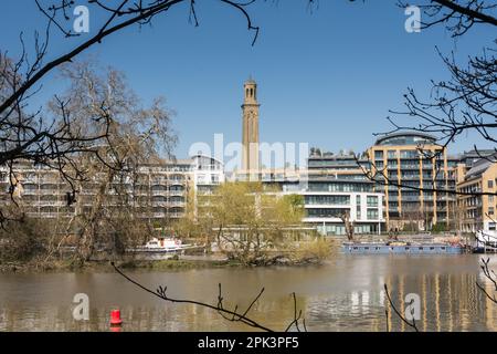 Hausboote auf einer ruhigen Themse mit Kew Bridge Road im hinteren Teil mit dem viktorianischen Standrohrturm Museum of Water & Steam Stockfoto