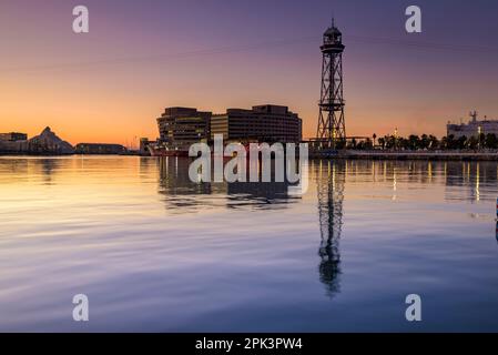 Port Vell (alter Hafen) von Barcelona, World Trade Center und Jaume I Tower bei Sonnenaufgang, mit ruhigem Mittelmeer und klarem Himmel (Spanien) Stockfoto