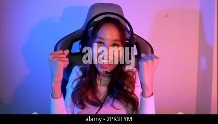 Junge Frau mit Kopfhörern, die Computerspiele spielt Stockfoto