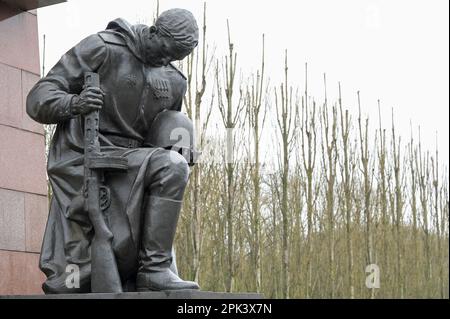 DEUTSCHLAND, ehemals Ost-Berlin, Treptow, sowjetischer Gedenkstein und Soldatenfriedhof mit 7000 Gräbern russischer Soldaten der Roten Armee im Treptower Park, erbaut 1946–49, kniender Soldat mit Pistole und Helm Statue, Heldenverehrung Stockfoto