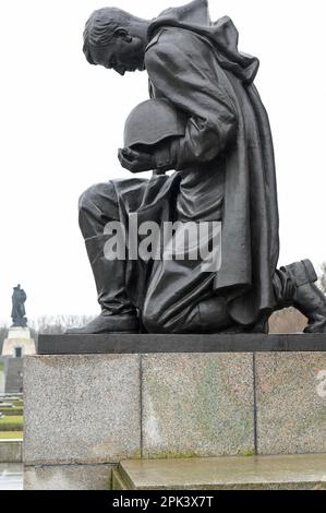 DEUTSCHLAND, ehemals Ost-Berlin, Treptow, sowjetischer Gedenkstein und Soldatenfriedhof mit 7000 Gräbern russischer Soldaten der Roten Armee im Treptower Park, erbaut 1946–49, kniender Soldat mit Pistole und Helm Statue, Heldenverehrung Stockfoto