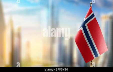 Kleine Flaggen Norwegens auf abstraktem, verschwommenem Hintergrund. Stockfoto