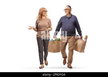 Ein vollständiges Porträt eines erwachsenen Mannes, der herumläuft, Einkaufstüten trägt und ein Gespräch mit einer Frau führt, isoliert auf weißem Hintergrund Stockfoto