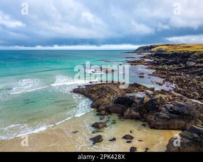 Isle of Lewis, Schottland. 5. April 2023 Wetter im Vereinigten Königreich: Das sonnige, türkisfarbene Wasser rund um den Hafen von Ness auf der schottischen Isle of Lewis aus der Vogelperspektive. Beliebte Touristenattraktion und Urlaubsziel in den Äußeren Hebriden. Kredit: Bradley Taylor / Alamy Live News Stockfoto