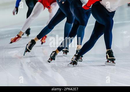 Männliche Skaterbeine machen einen Massenstart-Speed-Skating-Wettkampf, Wintersportspiele Stockfoto