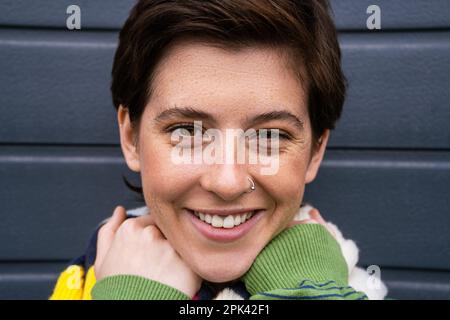 Porträt einer freudigen brünetten Frau mit Sommersprossen und Nasenlöchern, die im Frühling vor der Kamera lächelt Stockfoto