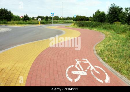 Rote Fahrradspur auf dem Bürgersteig entlang der Straße Stockfoto