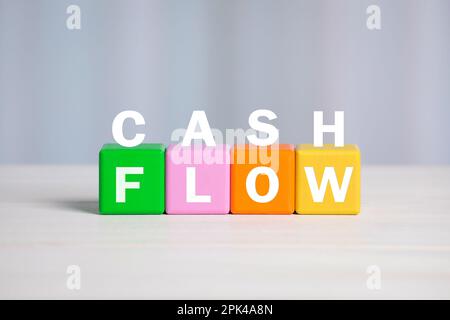 Satz Cashflow mit Buchstaben und bunten Würfeln auf hellem Hintergrund Stockfoto